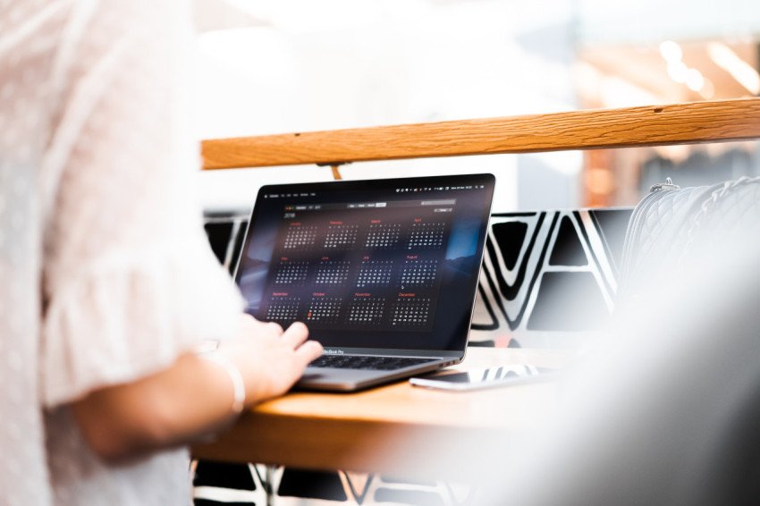 Woman using her macbook in a cafe free photo